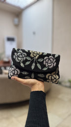 Side profile of the Rosette Flap clutch, illustrating its structured rectangular silhouette.