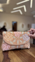 Open view of the Rosette handbag displaying its interior lining, spacious pocket, and magnetic snap.