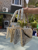 Side panel view of the Saanjh bag displaying the unique half-chain belt connection.