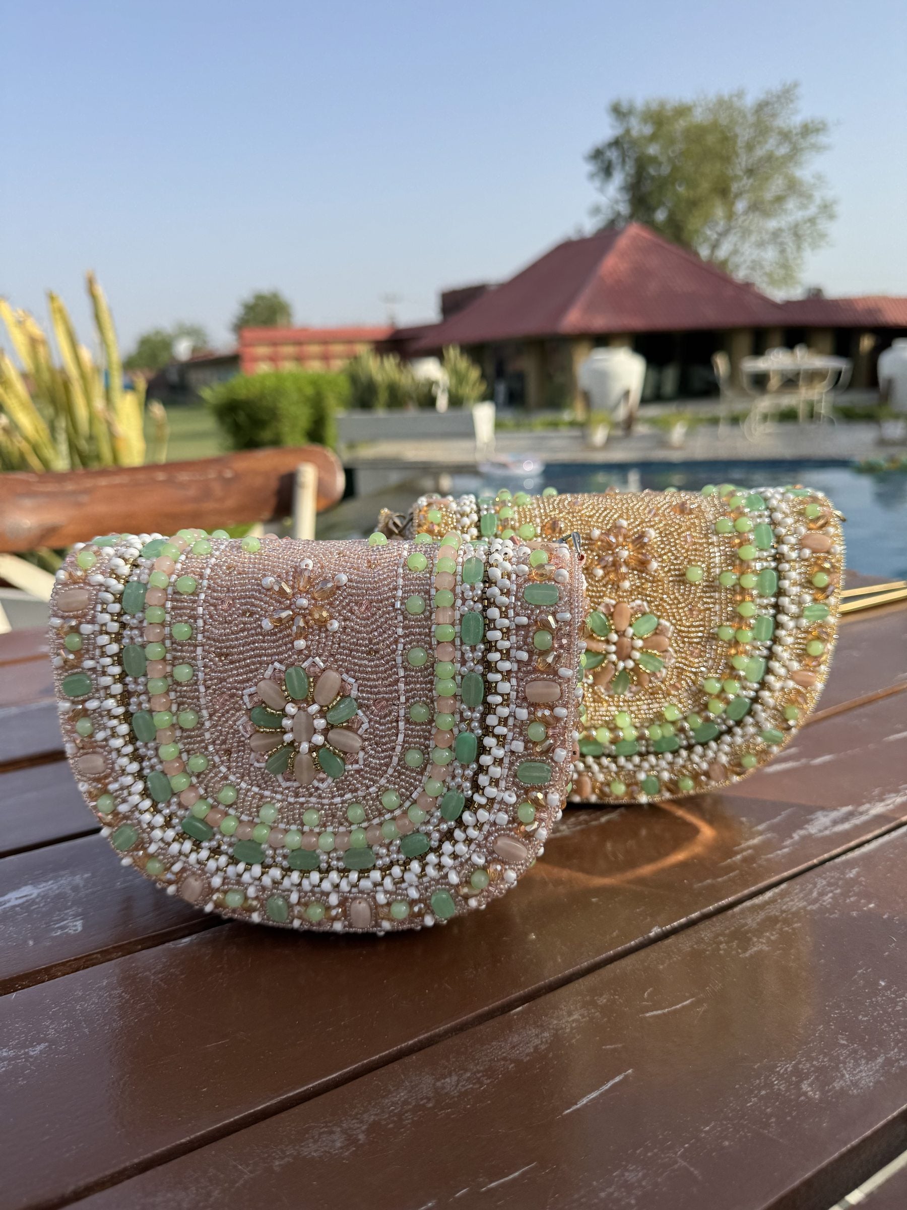 Front view of the Sage Blush Clutch showing its soft sage green fabric and beaded handle.