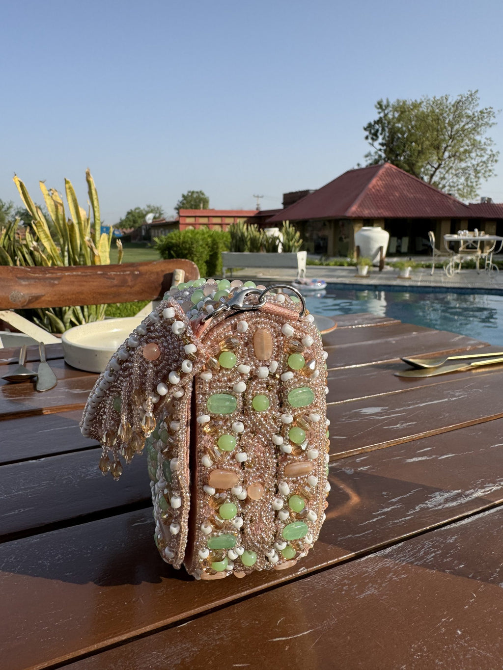 Model styling the Sage Blush bag handheld with a pastel peach outfit.