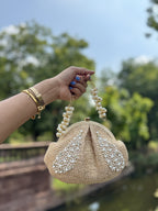 Model styling the Sands & Pearls bag handheld with a linen sundress.