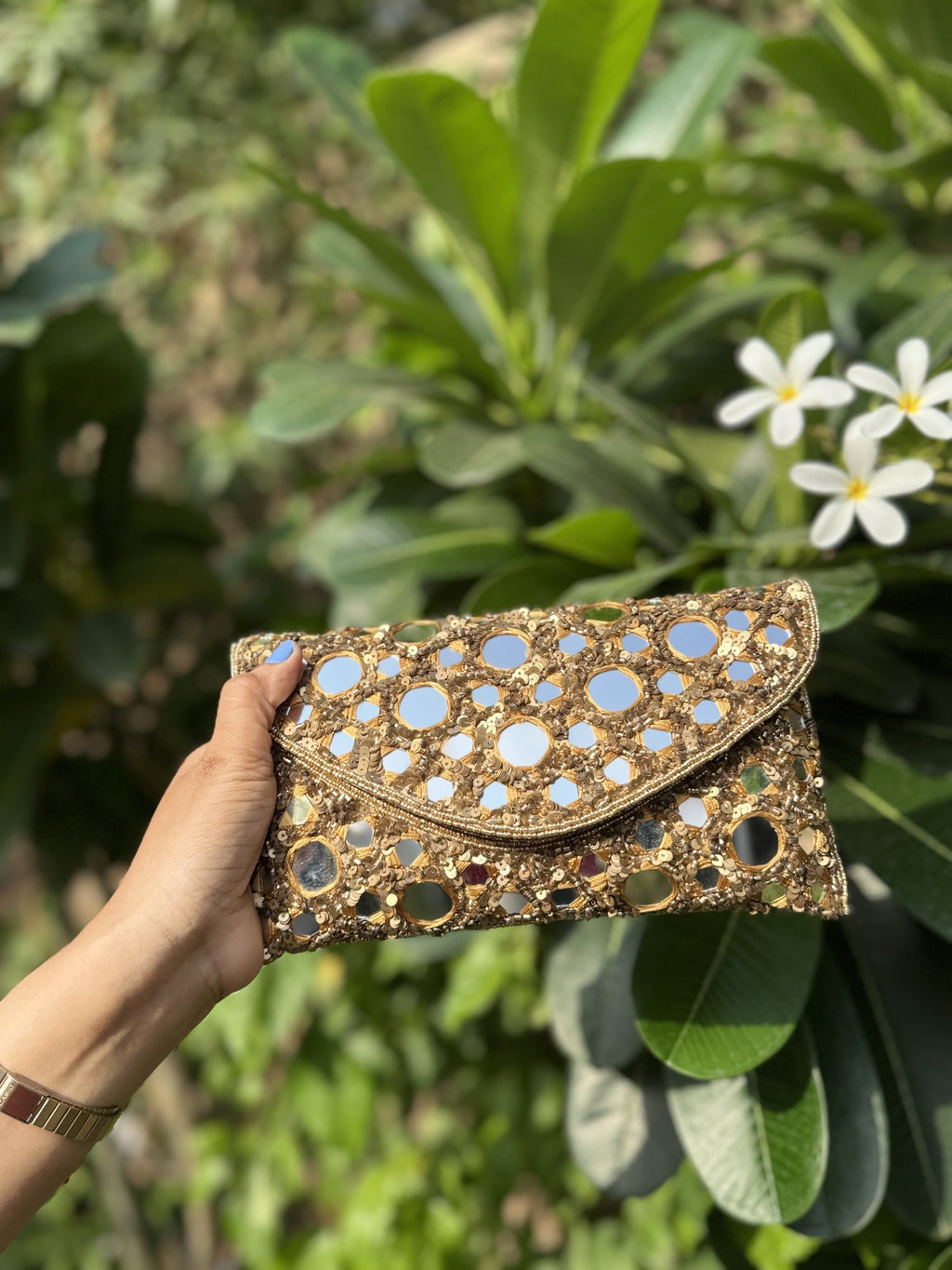 Angled view of the Sheesha Flap bag with its short beaded wrist handle attached.