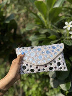 Open view of the Sheesha handbag displaying its fabric lining, spacious pocket, and magnetic snap.