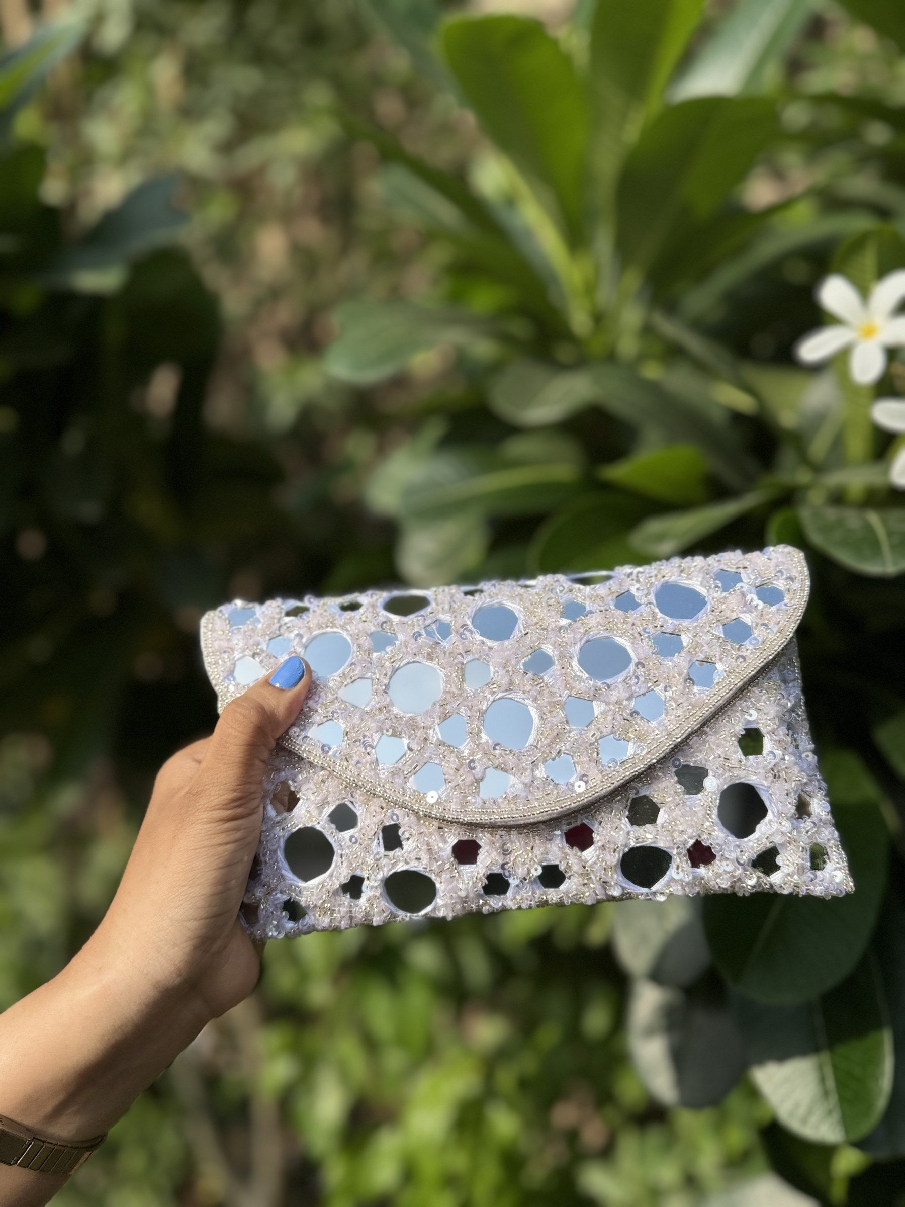 Open view of the Sheesha handbag displaying its fabric lining, spacious pocket, and magnetic snap.