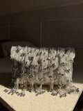 Starlace flap bag displaying its heavy hand embroidery and cascading tassels.