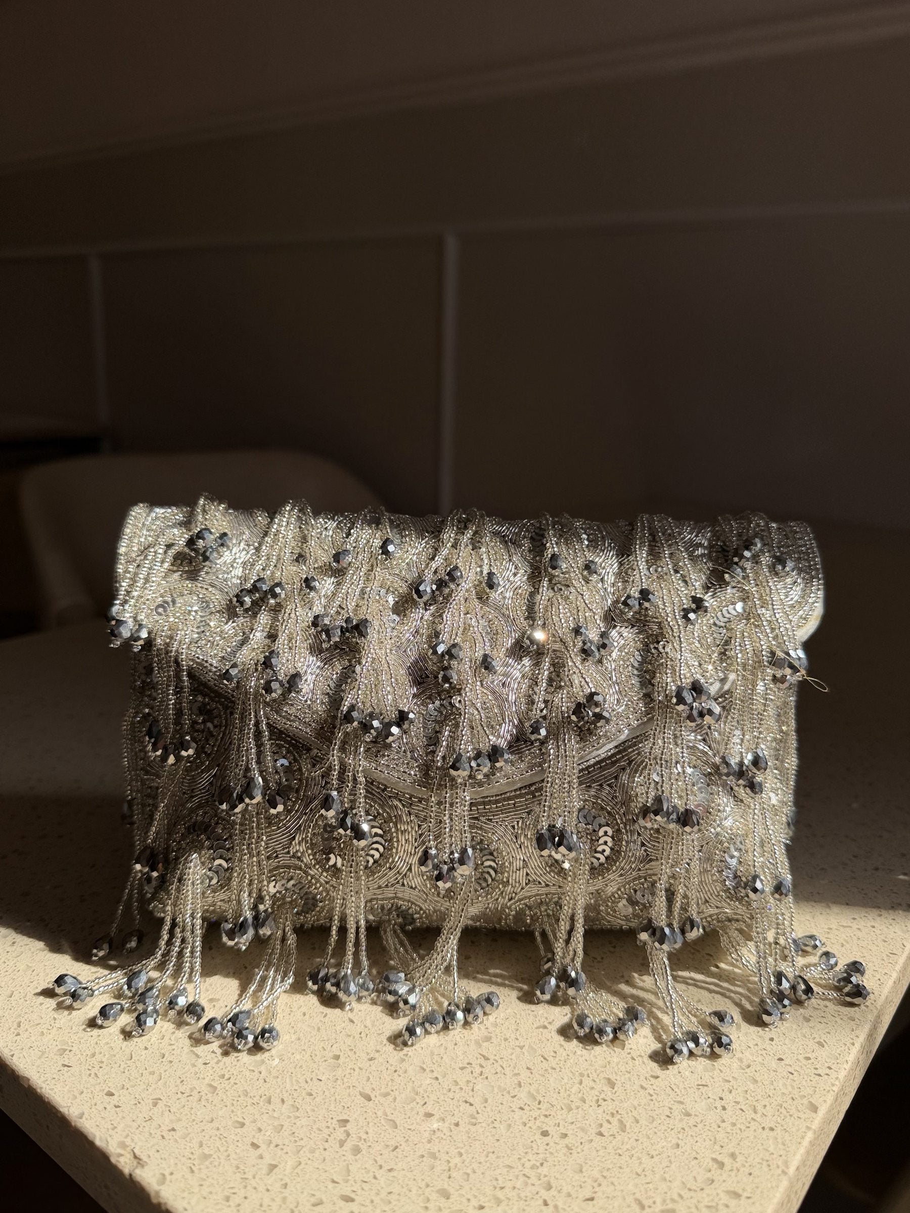 Starlace flap bag displaying its heavy hand embroidery and cascading tassels.