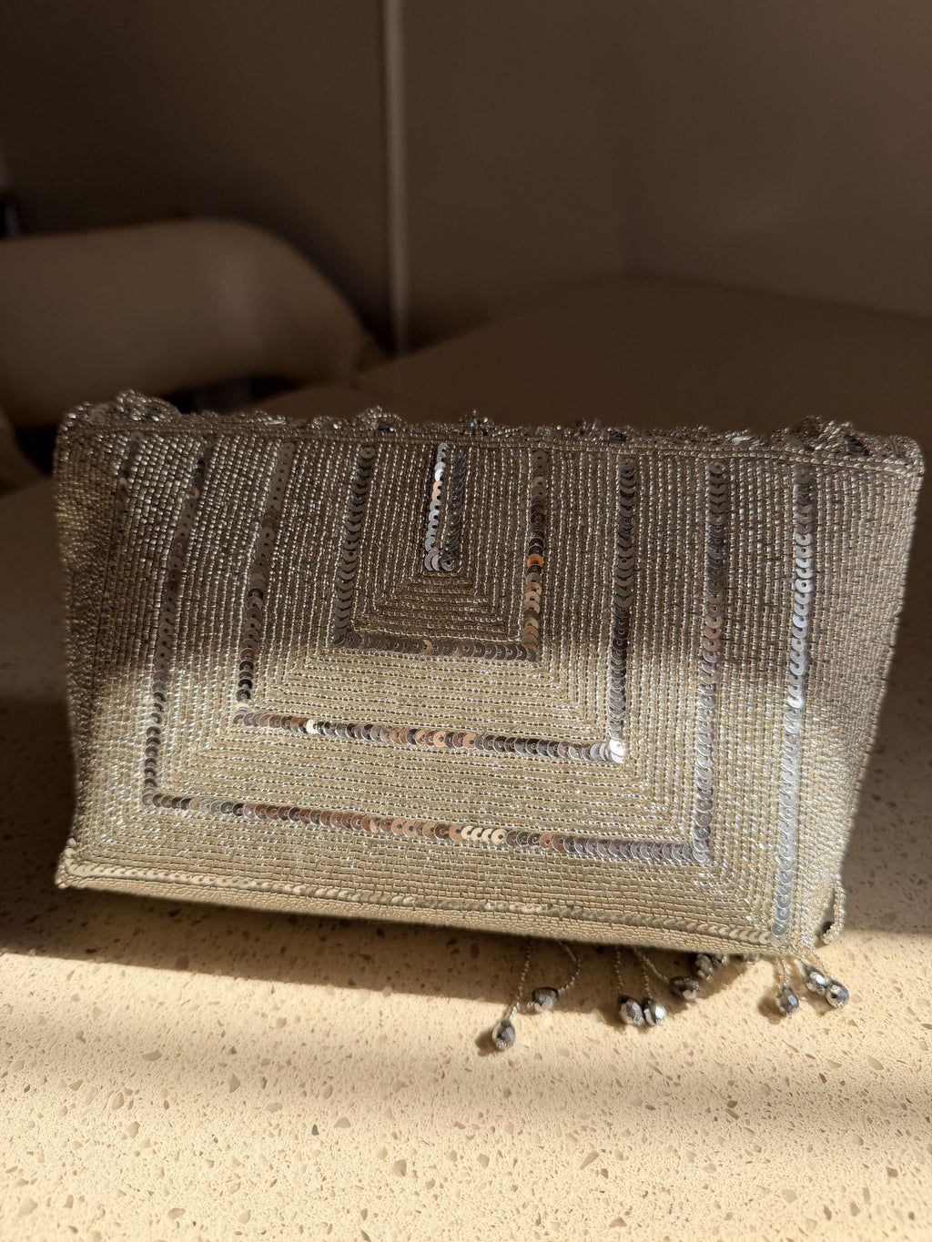 Detailed close-up of the hand-stitched glass beads and metallic thread tassels.