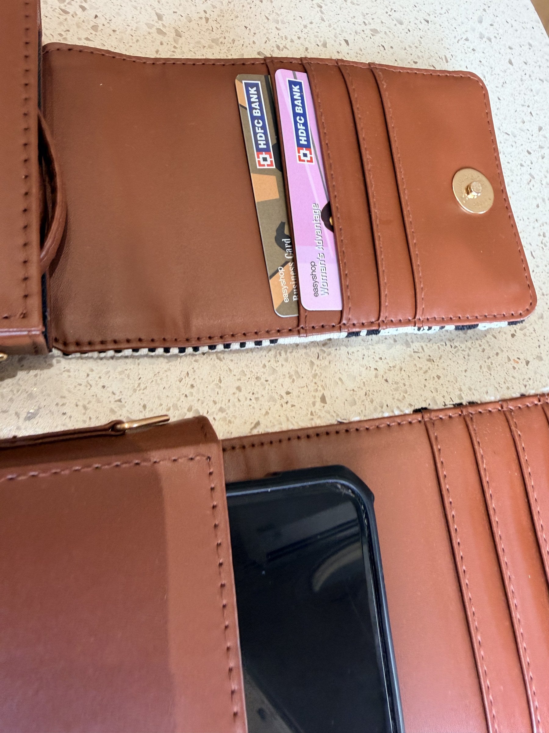 The Strap and Stow bag lying flat with travel essentials: passport, keys, and phone.