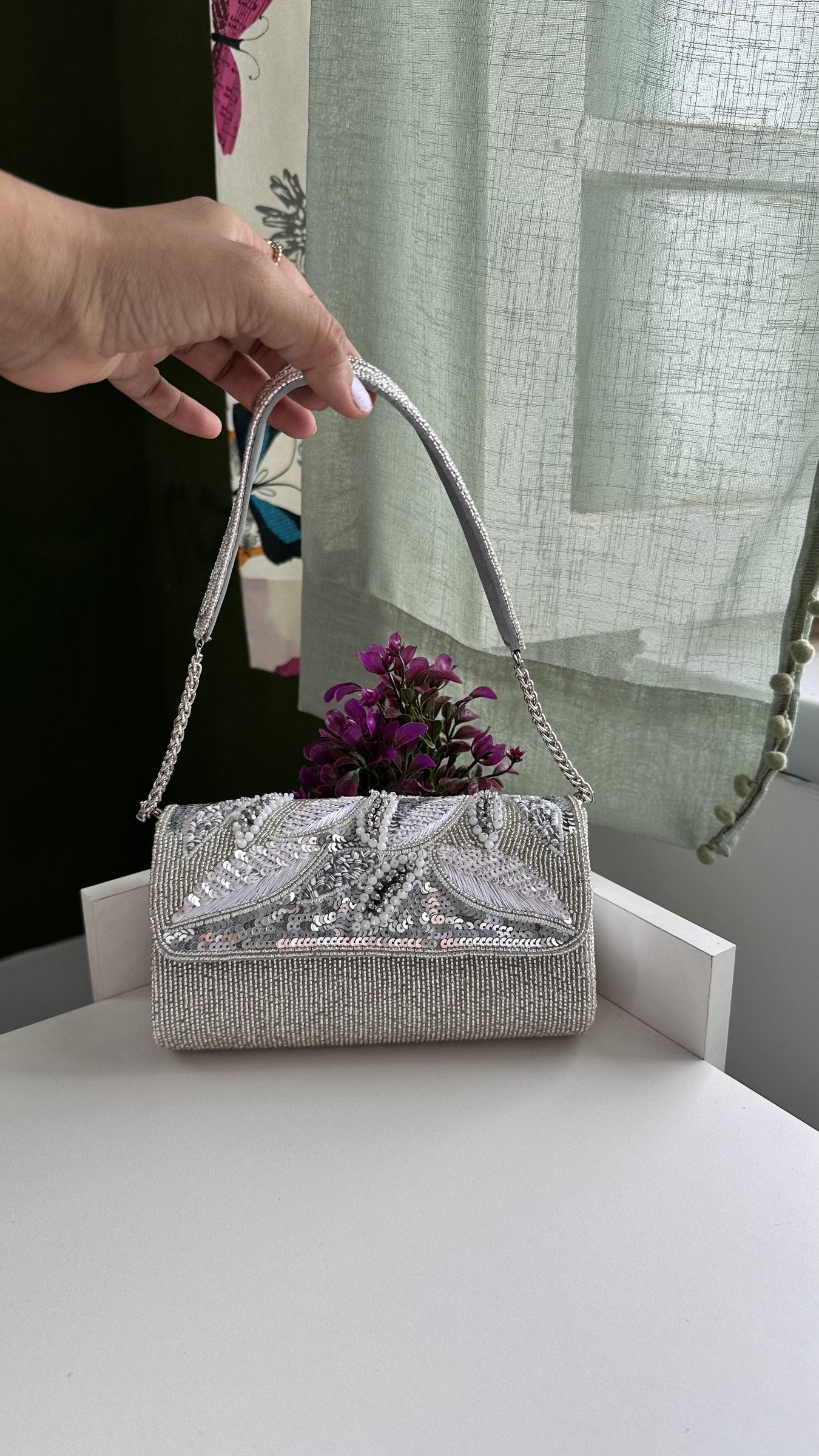 Model styling the Sunara bag handheld with an ivory resort gown.
