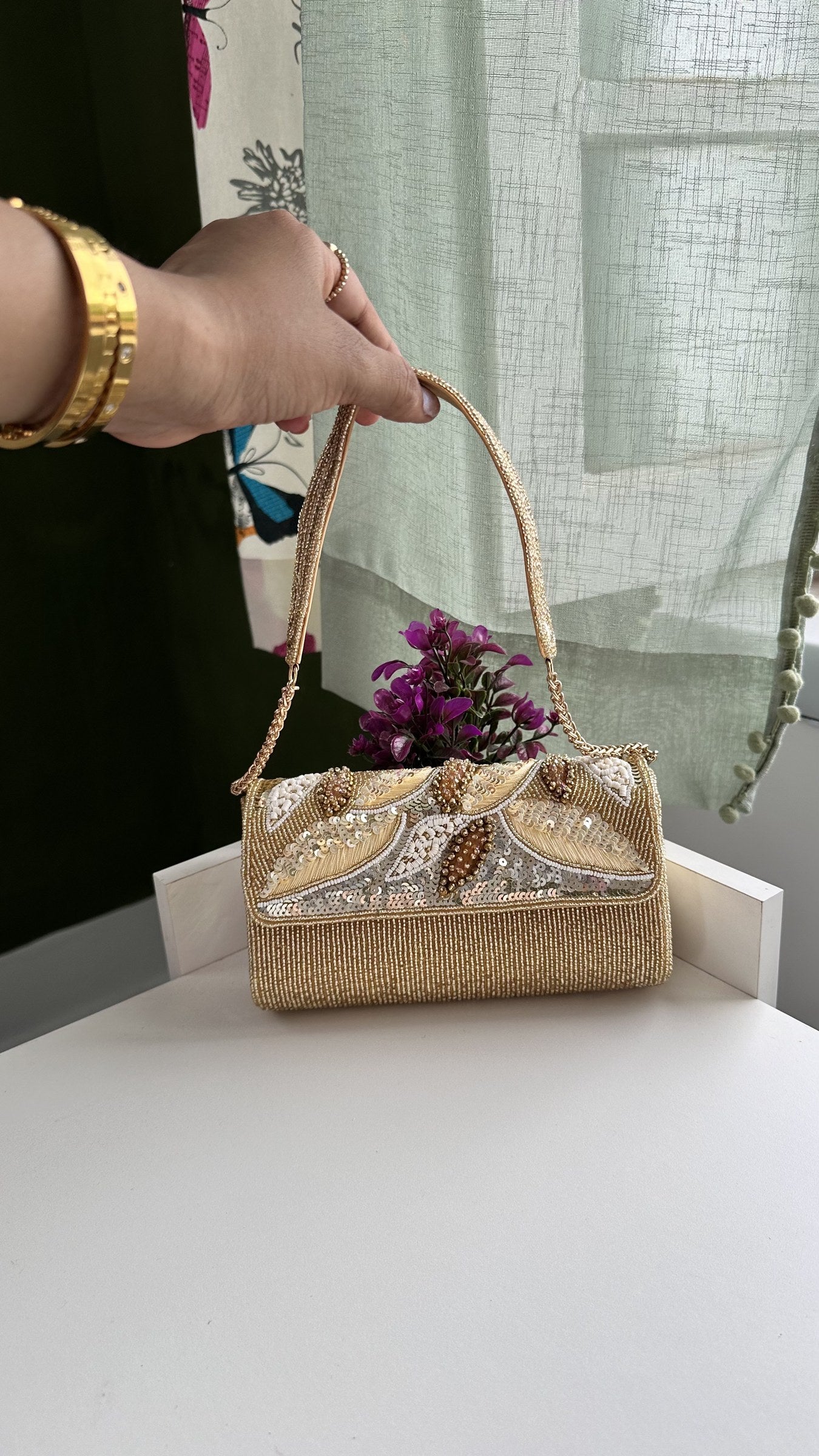 Flat lay of the Sunara bag with gold jewelry and sunglasses.
