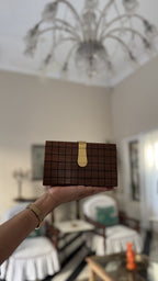 Handheld view showcasing the compact size and textured checkerboard pattern.