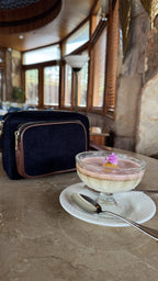 The Corduroy Edit bag resting on an open book in a library, capturing its academic aesthetic.