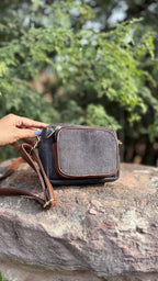 Close-up of the metal clasp connecting the corduroy shoulder strap to the bag body.