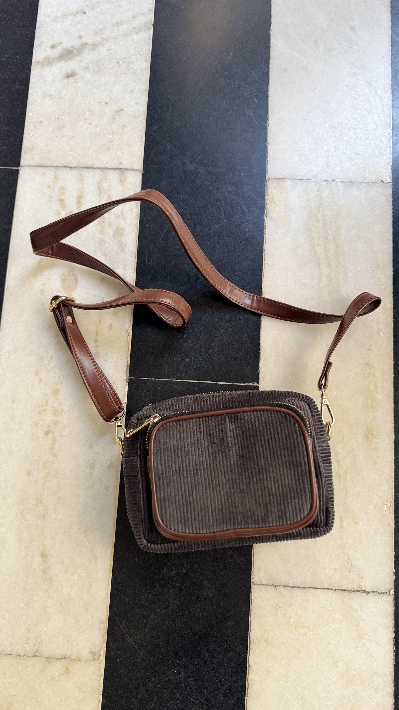Detail of the adjustable buckle on the matching corduroy shoulder strap.