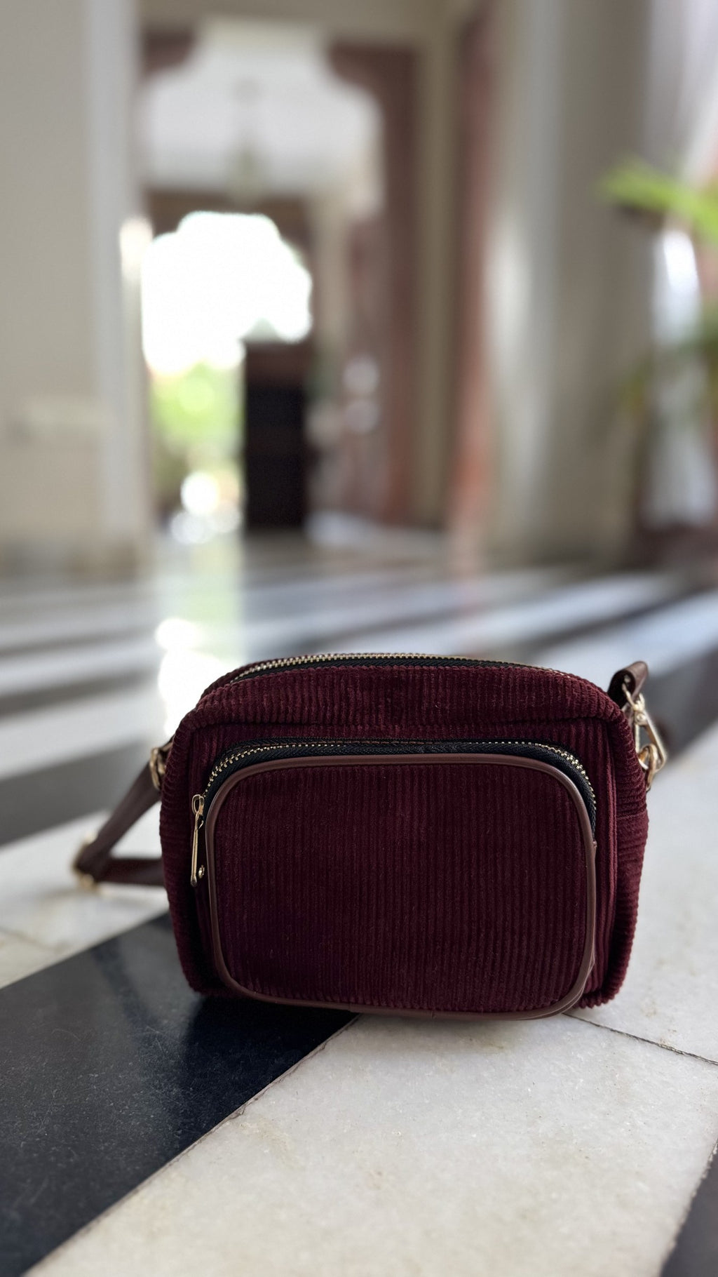 High angle view of the corduroy bag showing the clean stitching on the strap attachment loops.