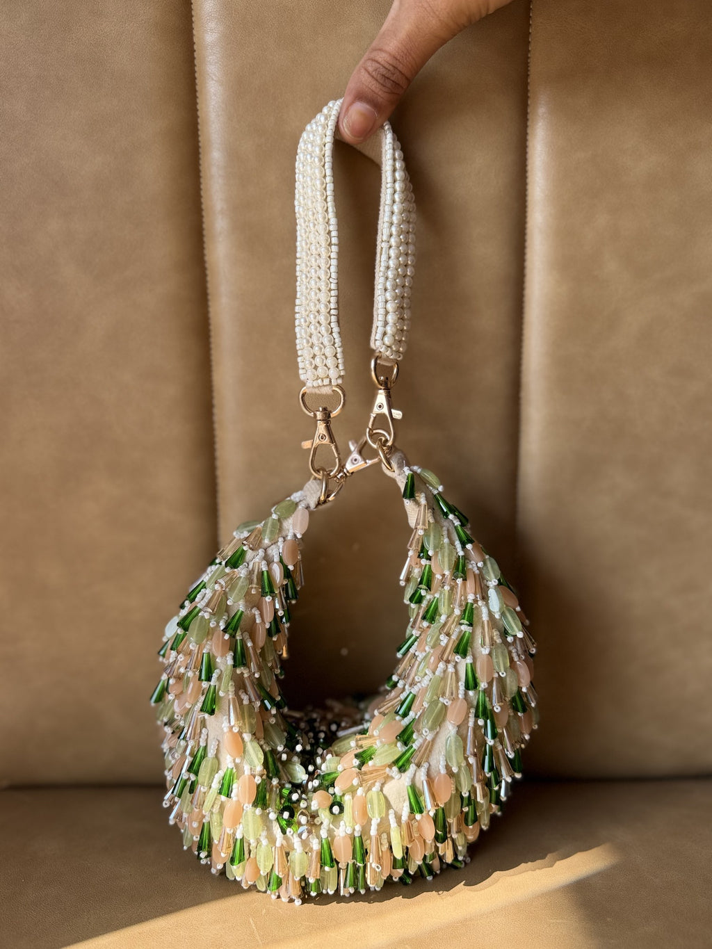 Side angle of the Opal Edit bag showcasing its freeform shape and chain attachments.