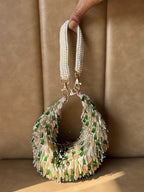 Side angle of the Opal Edit bag showcasing its freeform shape and chain attachments.