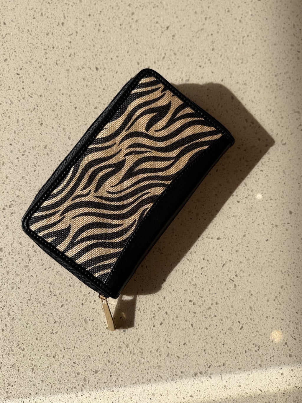 Close-up of the gold-tone zippered partition and dual cash pockets inside the wallet.