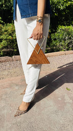 Trikon Luxe triangular wooden clutch displaying its unique geometric shape, sheesham grain, and brass push lock.