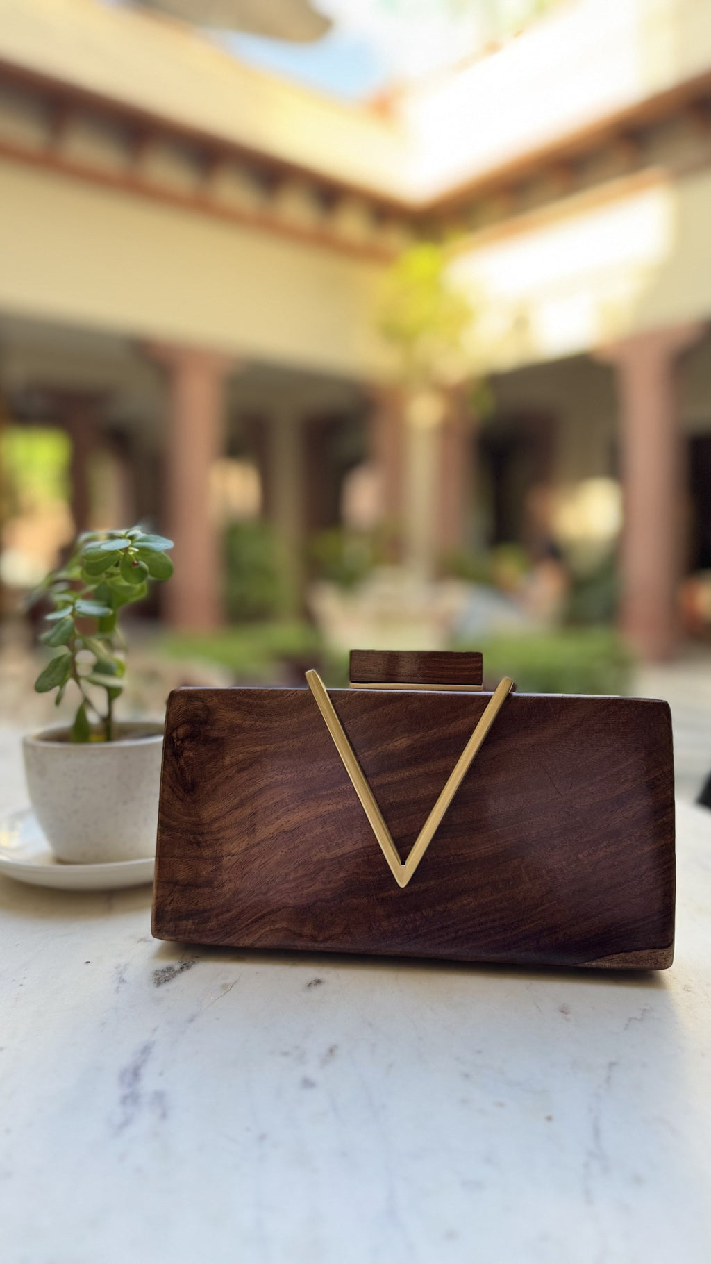 Angle view showcasing the V-shaped slope and gold brass clasp.