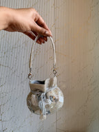 Angled view of the mini potli showing its drawstring closure and beaded wrist handle.