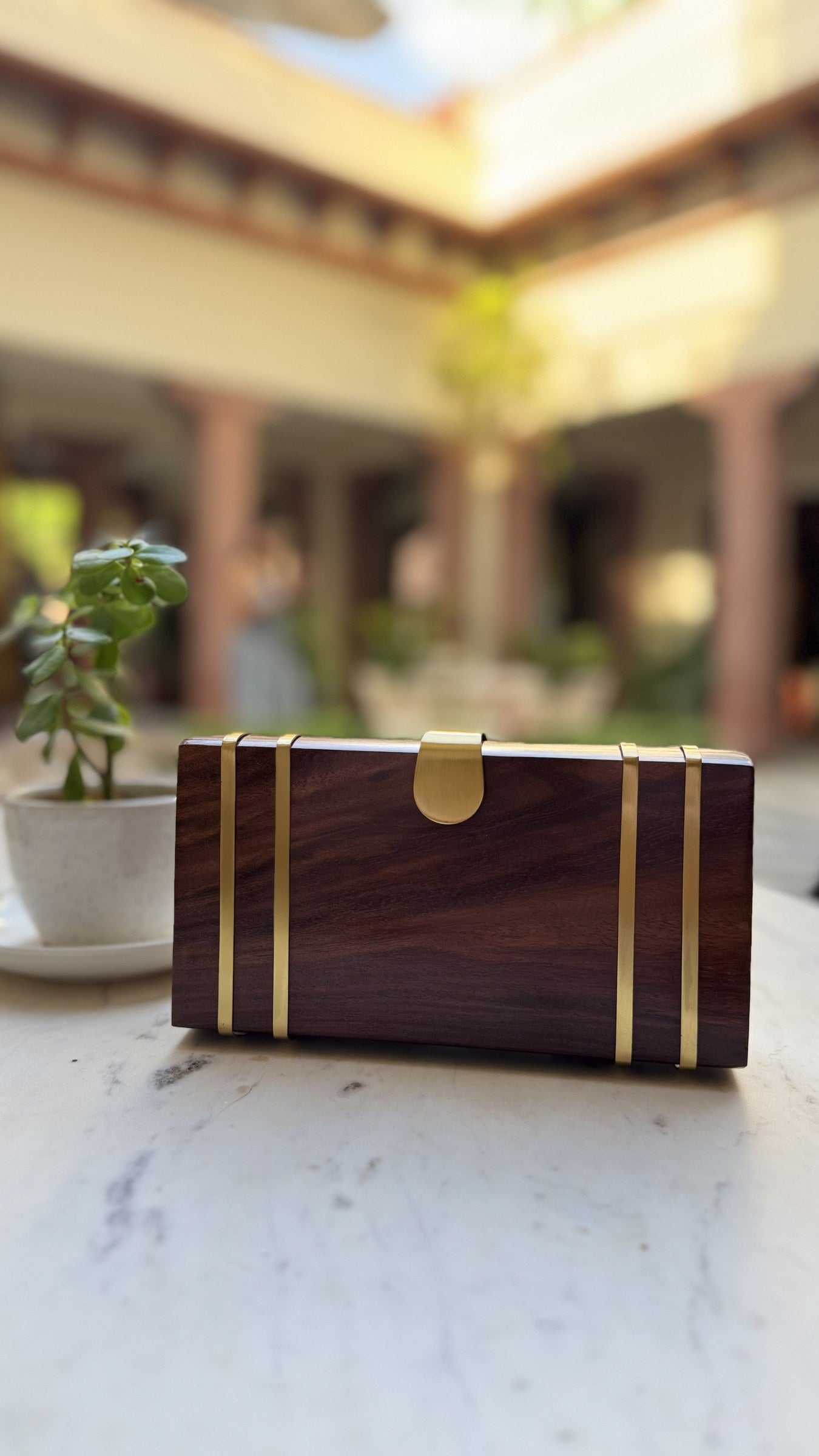 Wood Box wooden clutch showing its clean rectangular silhouette, wood grain, and gold brass hinges.