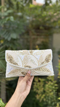 Zaraa Blossom flap bag displaying its pink and green floral embroidery and gold-tone sling chain.