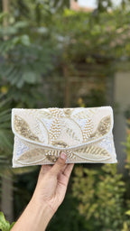 Zaraa Blossom flap bag displaying its pink and green floral embroidery and gold-tone sling chain.